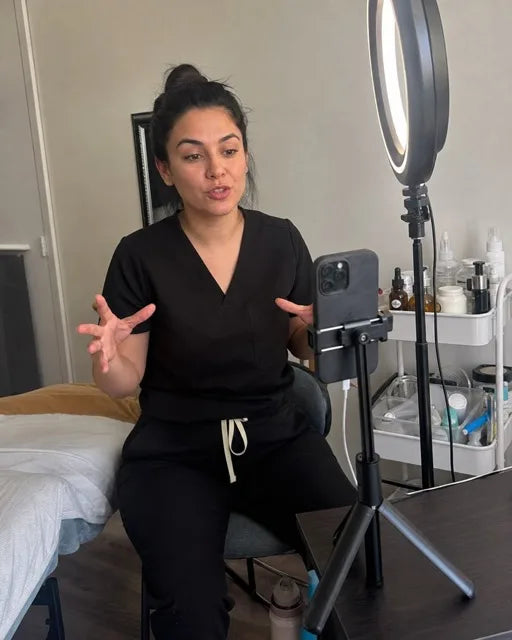 Cosmetóloga grabando un video con el celular y aro de luz en su cabina
